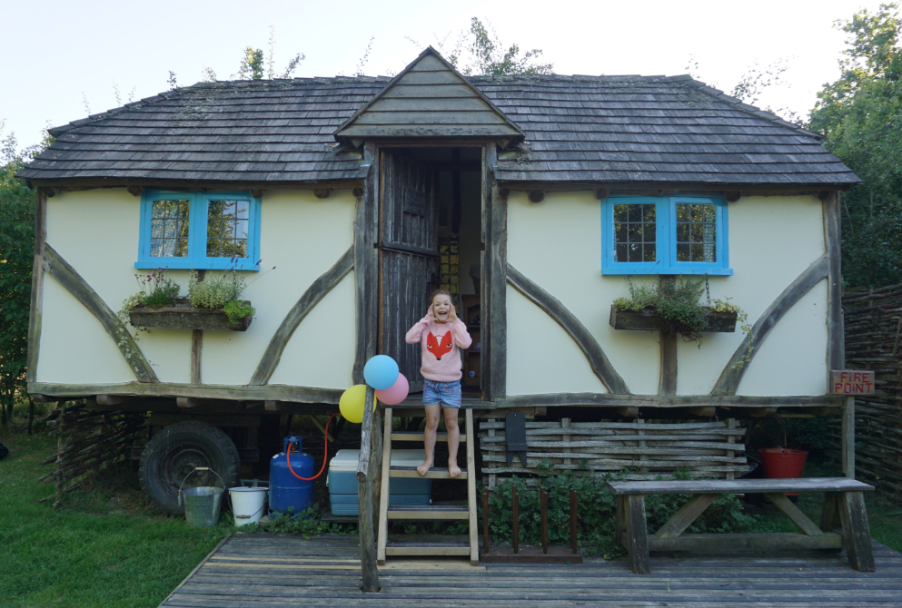 Child on steps at Swallowtail Hill glampsite in East Sussex